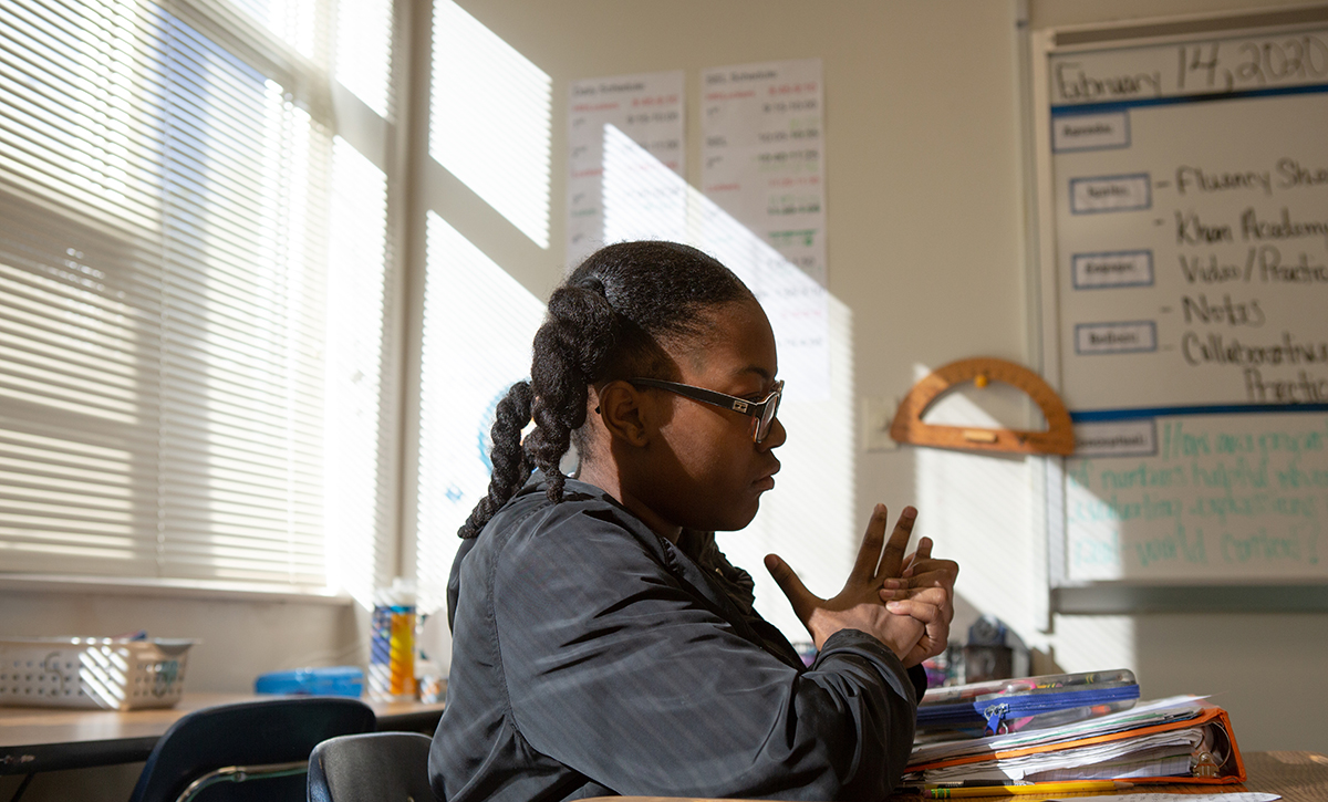 A sixth-grade student sits alone at a desk in math class.
