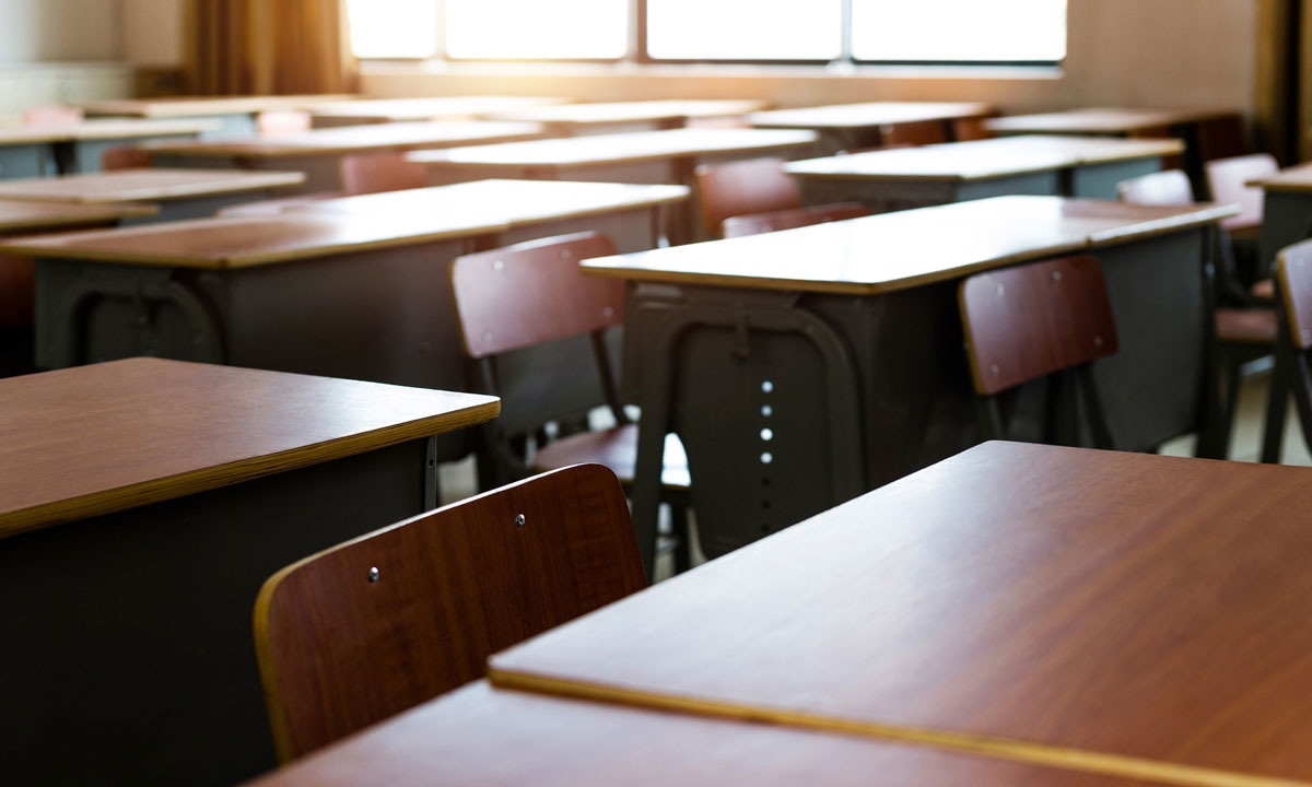 This is an image of empty desks in a classroom.
